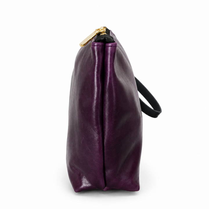 A side view of a purple leather bag with a black strap and a gold zipper pull, shown on a white background.