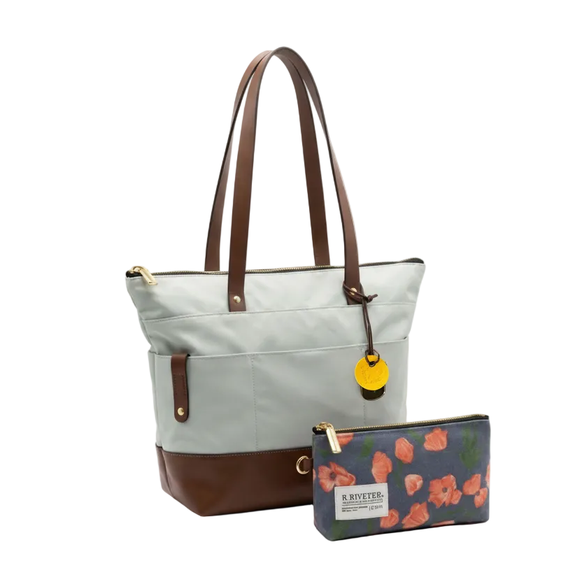 Light blue tote bag with brown accents and a matching pouch with floral design on a white background