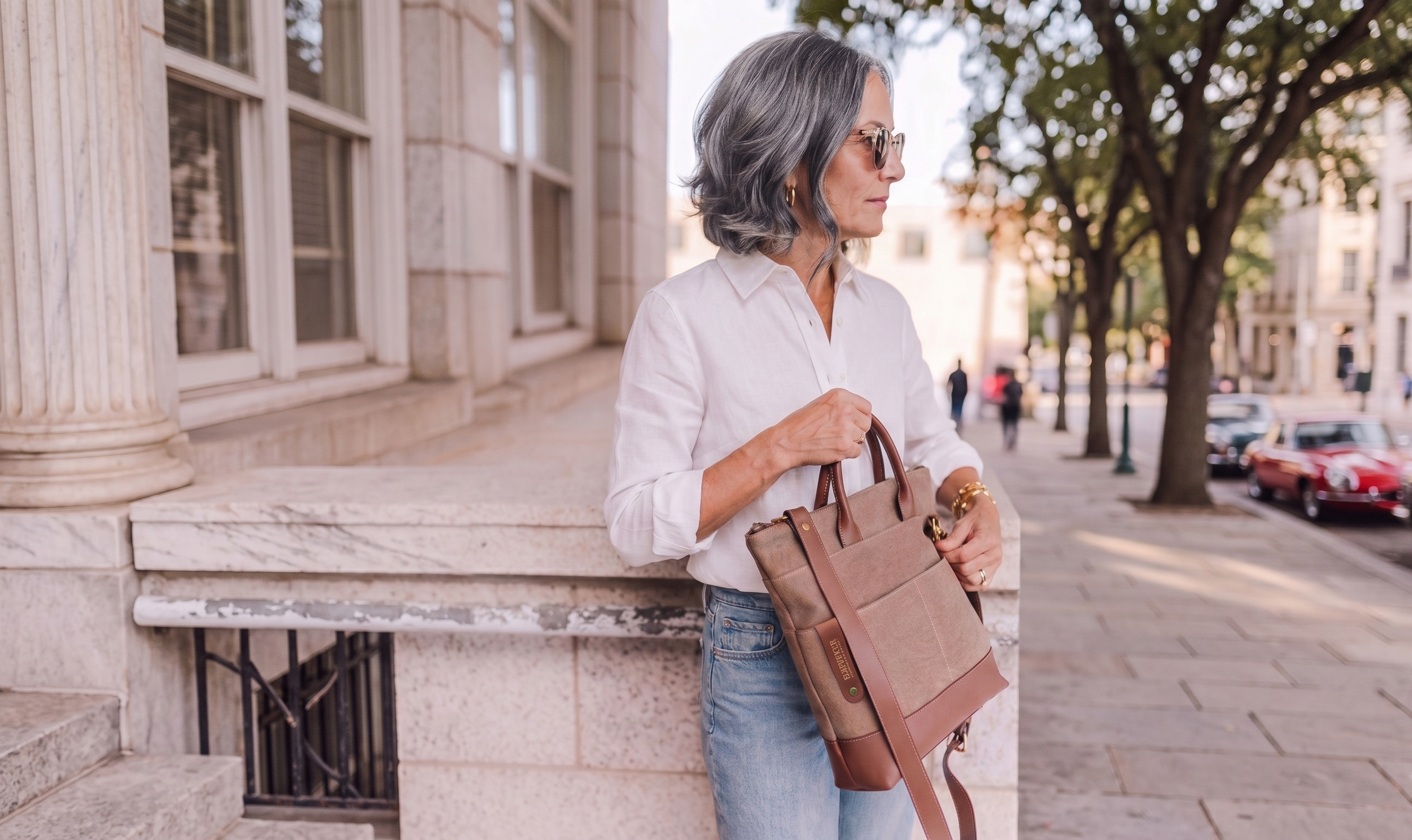 Woman holding a brown leather bag on a city street