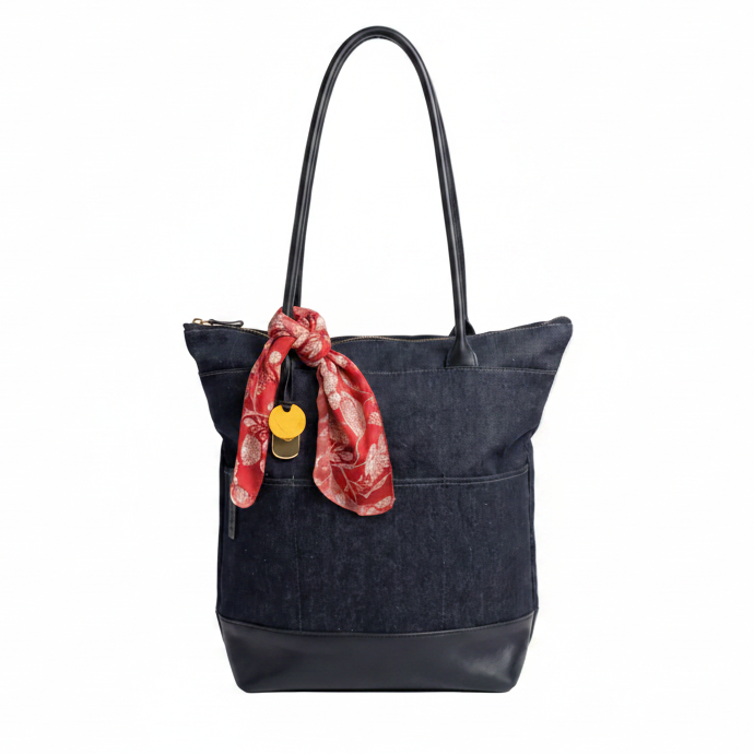 Black tote bag with a red scarf and yellow tag on a white background