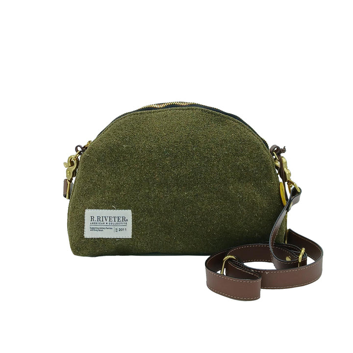 Green crossbody bag with a visible brand label on a white background