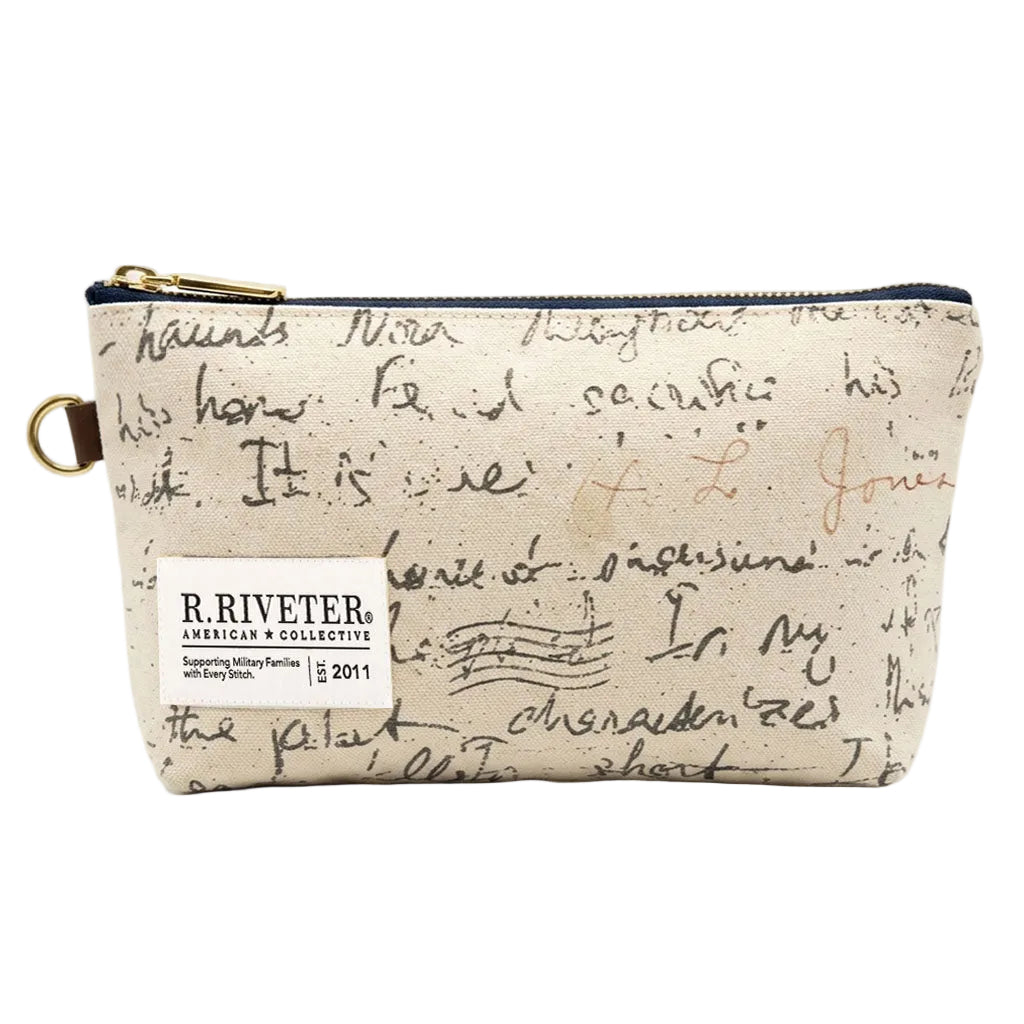 A beige canvas zippered pouch with a black script print, featuring a white sewn-on label that reads 'R. RIVETER AMERICAN • COLLECTIVE' and gold-tone hardware.