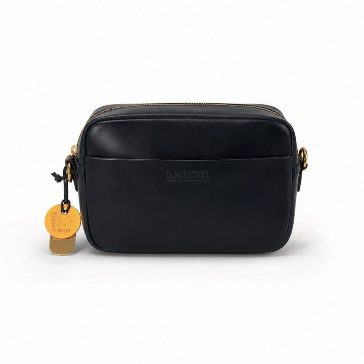 A black leather camera bag with gold-tone hardware, featuring a front zip pocket, a hanging gold tag, and the embossed brand name 'EL RIVIERA' on the front, set against a plain white background.