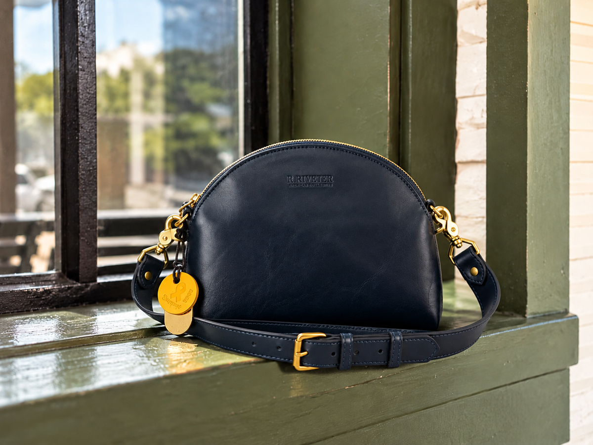 Inkwell Blue leather bags arranged together beside a marina