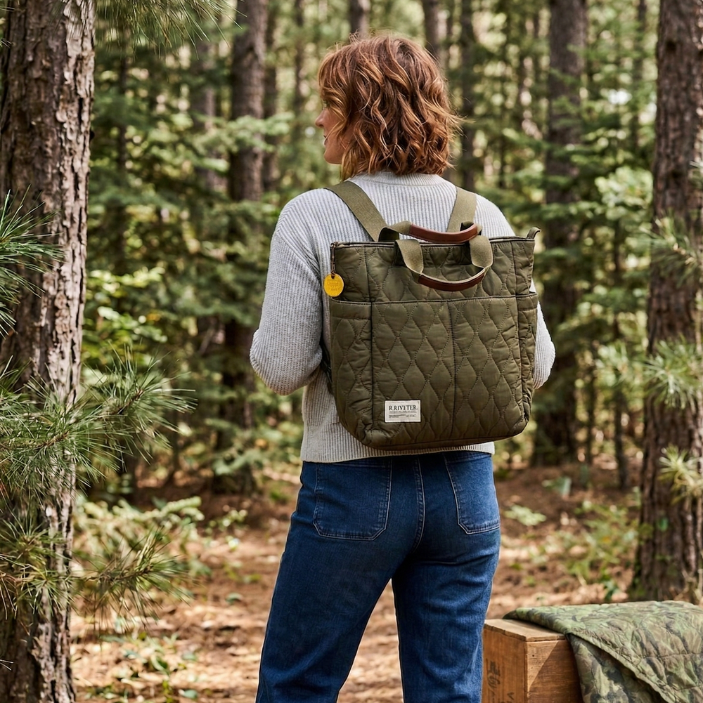 Person with a green quilted backpack walking through a forest