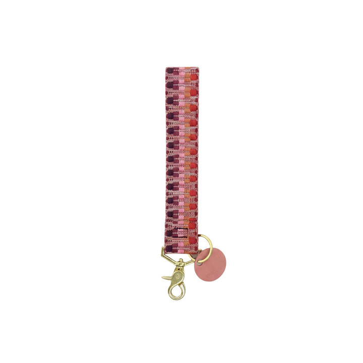 Multicolored patterned keychain with a pink charm on a white background