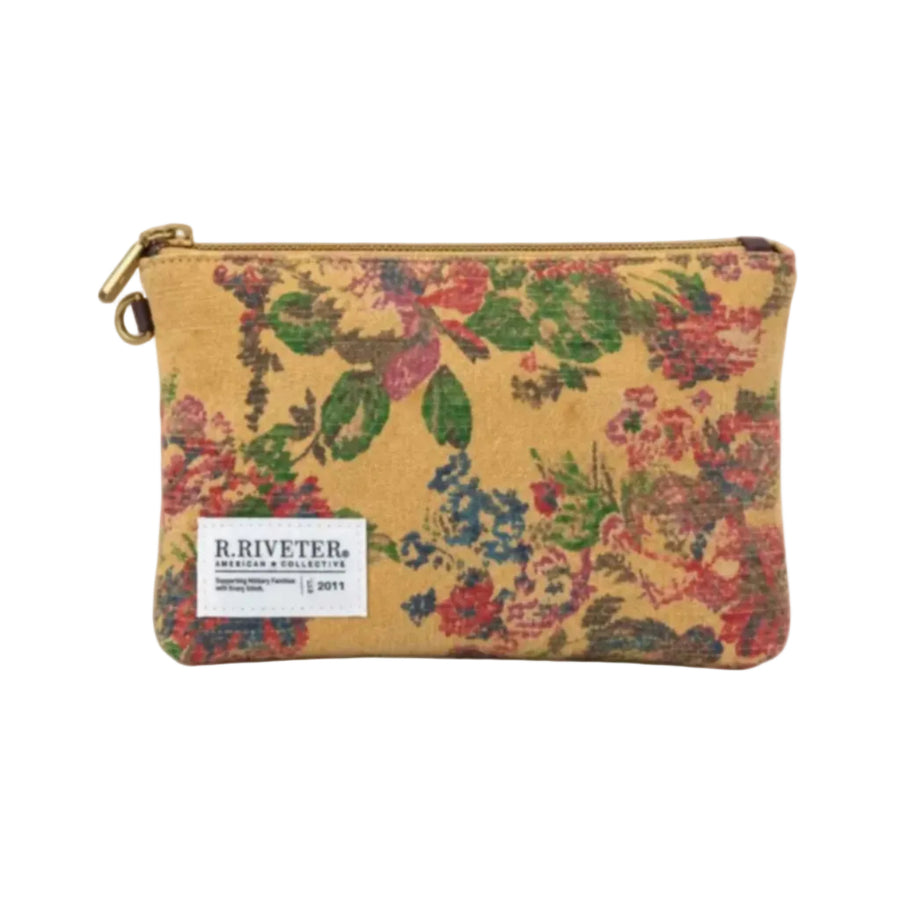 A R. Riveter American Collective zippered pouch featuring a vintage floral tapestry pattern in muted red, green, and blue on a tan background, with a white brand label on the front.