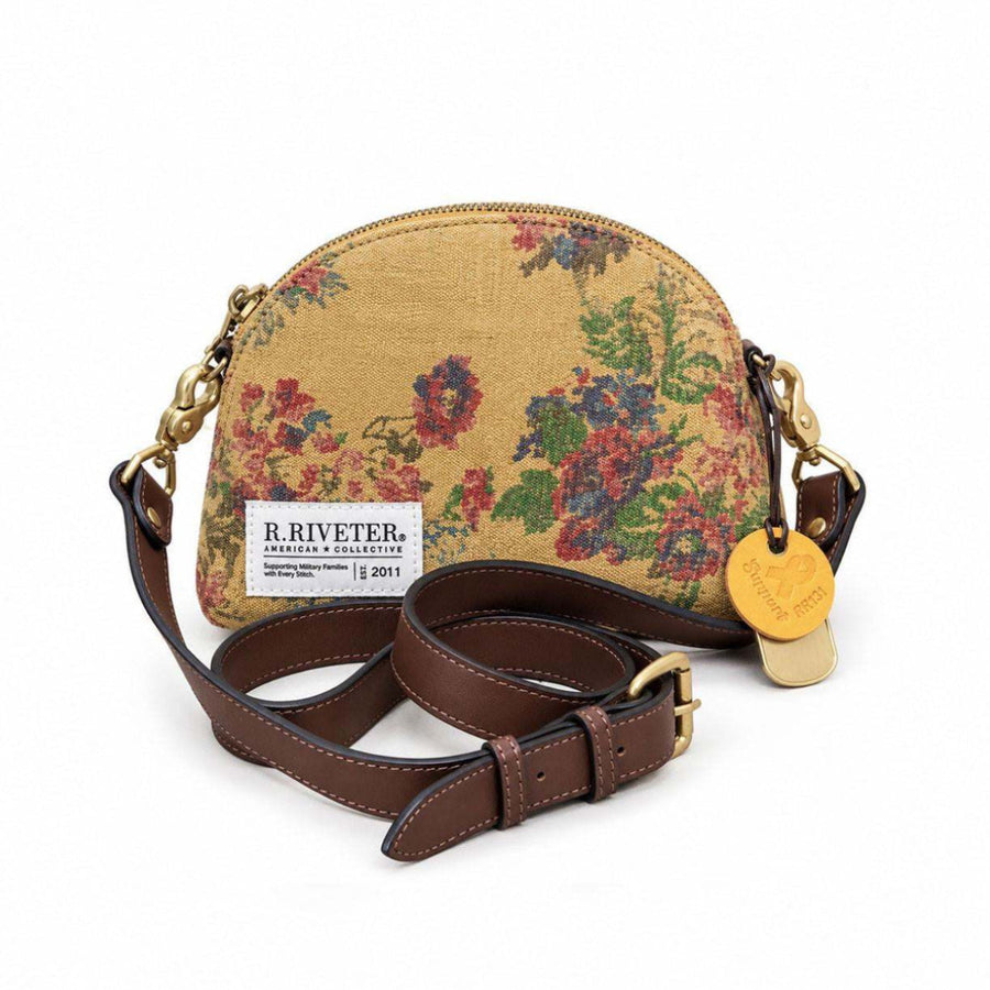 A R. Riveter handbag featuring a gold-toned fabric body with a colorful floral tapestry pattern, a brown leather shoulder strap, and gold-tone hardware, shown on a white background.